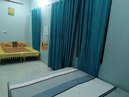 ein Schlafzimmer mit blauen Vorhängen und einem Bett darin in der Unterkunft Shree Banke bihari home stay in Mathura