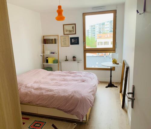 une petite chambre avec un lit et une fenêtre dans l'établissement Appart 61 m2, lumineux, sans vis à vis, balcon, à Montreuil