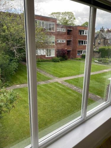 an open window with a view of a yard at Stylish 2-Bed flat in North Leeds, great location in Leeds
