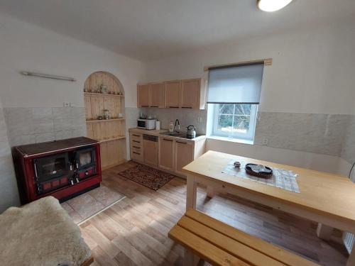 a kitchen with a table and a stove in it at Chalupa u Desné in Petrov nad Desnou