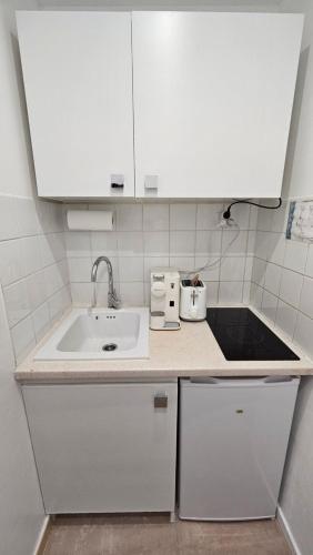 a small kitchen with a sink and white cabinets at PROCHE CONGRES PLAGES CLIM in Cannes