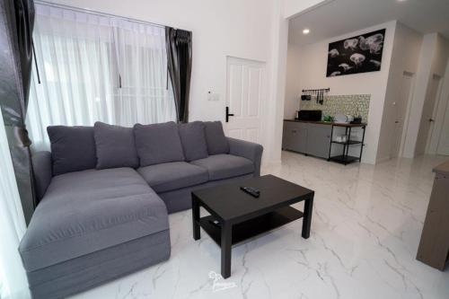 - un salon avec un canapé et une table dans l'établissement Kanchanaburi Modern Home, à Kanchanaburi