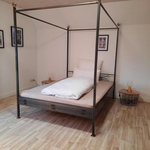 a bedroom with a four poster bed with white sheets at Große Ferienwohnung im Spreewald Lübben 2,5km in Hartmannsdorf