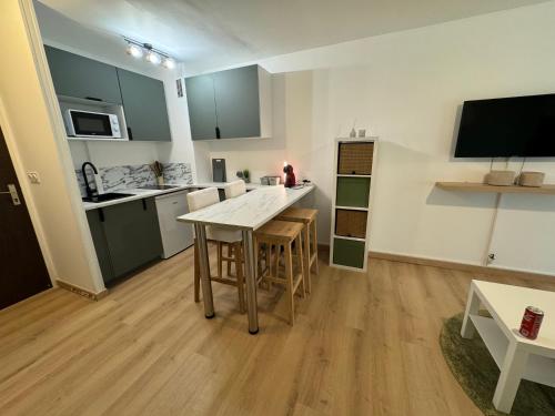 cocina y sala de estar con mesa. en Appartement à 2 min des plages, en Trouville-sur-Mer