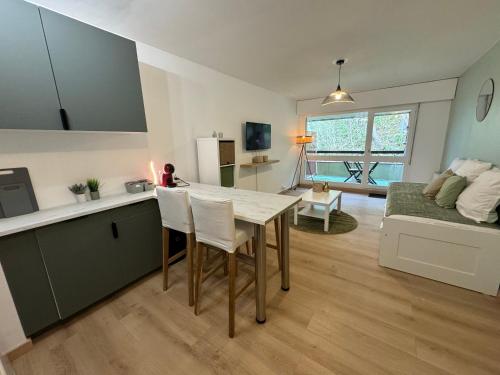 cocina y sala de estar con mesa y sofá en Appartement à 2 min des plages, en Trouville-sur-Mer