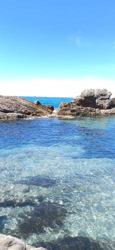 a body of water with rocks in the water at FLORA STUDIOS CORFU - Adults only in Benitses