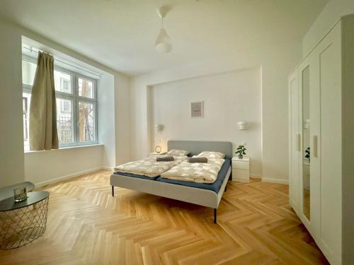 um quarto com uma cama e piso em madeira em AR Living Vienna Apartments & Suites em Viena