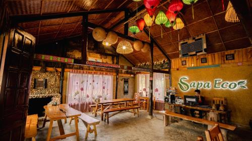 una stanza con tavoli e sedie e un cartello sul muro di Sapa Eco Bungalows & Spa a Sa Pa