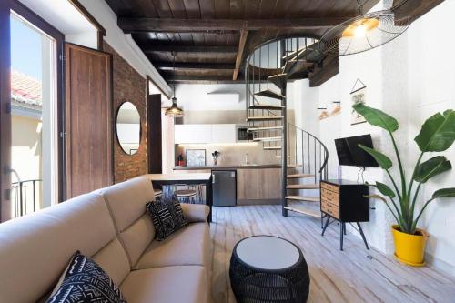 een woonkamer met een bank en een trap bij Apartamentos Simba in Málaga