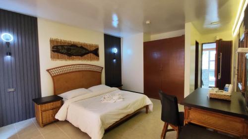 a bedroom with a bed and a desk and a desk at Eagle Point Beach and Dive Resort in Mabini