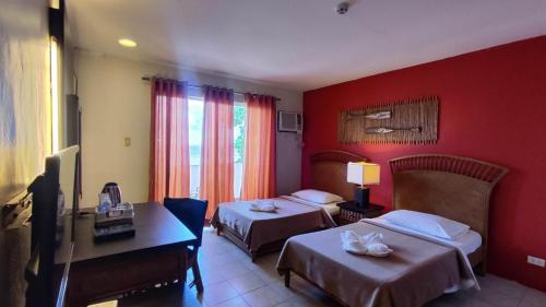 a hotel room with two beds and red walls at Eagle Point Beach and Dive Resort in Mabini