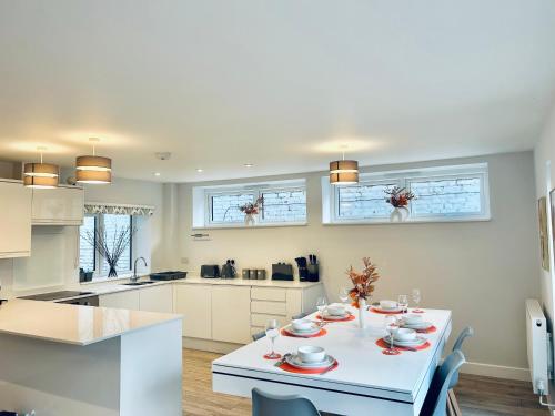 een keuken met een witte tafel met borden erop bij Luxury Town Centre House, Faversham in Faversham
