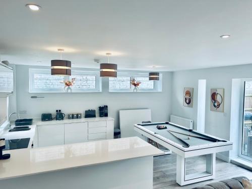 a kitchen with white cabinets and a white table at Luxury Town Centre House, Faversham in Faversham
