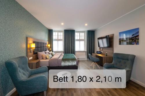 a hotel room with a bed and two chairs at AKZENT Hotel Restaurant Roter Ochse Rhens bei Koblenz in Rhens