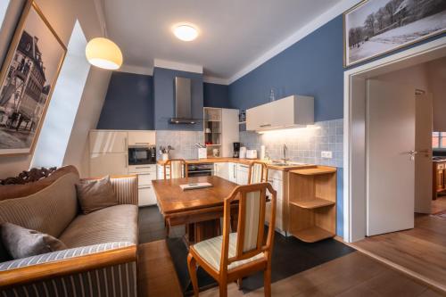 eine Küche und ein Wohnzimmer mit einem Tisch und einem Sofa in der Unterkunft Altstadt Palais in Weimar