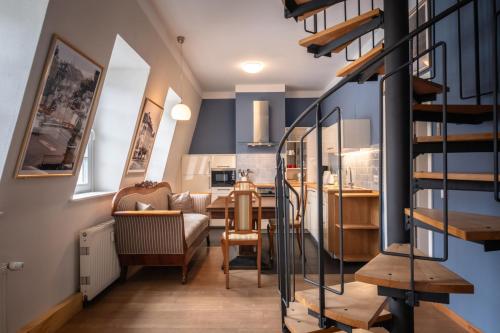 ein Wohnzimmer und eine Küche mit einer Wendeltreppe in der Unterkunft Altstadt Palais in Weimar