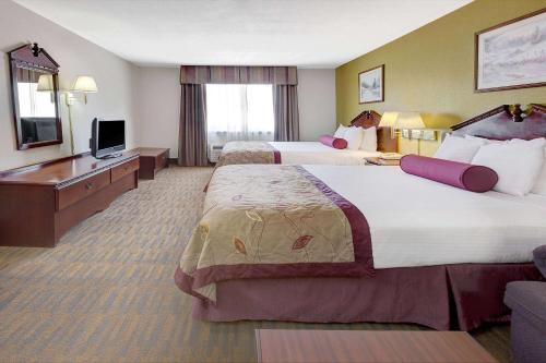 Habitación de hotel con 2 camas y TV de pantalla plana. en Baymont by Wyndham El Reno, en El Reno