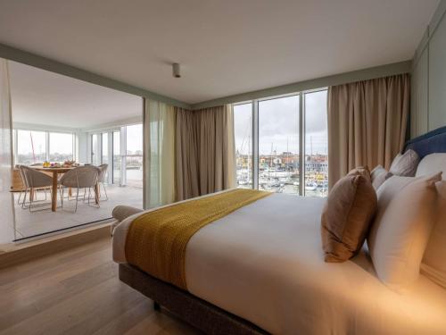 a bedroom with a large bed with a large window at Mercure La Rochelle Vieux Port in La Rochelle
