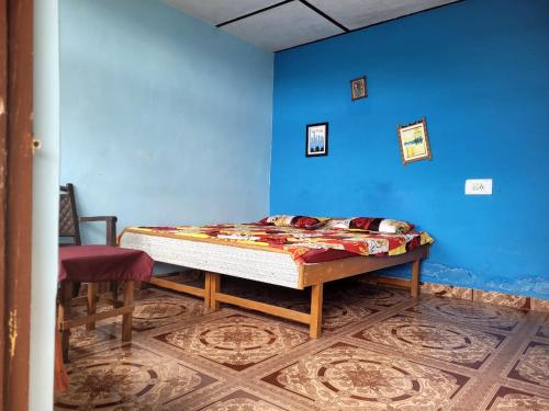 Cama en habitación con pared azul en Namaste Bhagsu - Rooms & Rooftop Cafe en Dharamshala