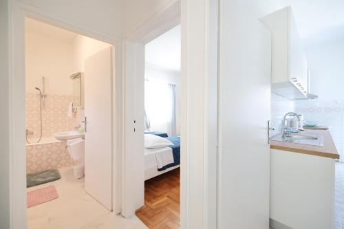 a white bathroom with a bed and a sink at One bedroom apartment Dragica in Zadar
