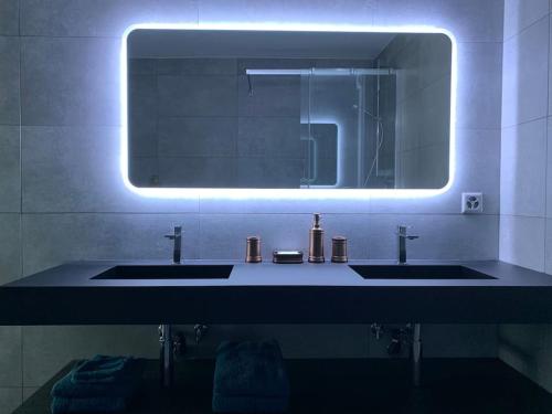 a bathroom with two sinks and a large mirror at Crans Paradise in Crans-Montana