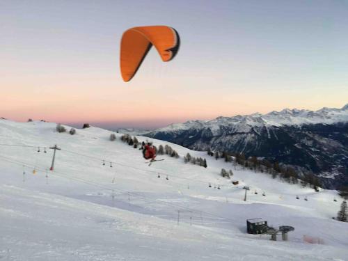 a person riding a kite on a snow covered slope at Crans Paradise in Crans-Montana