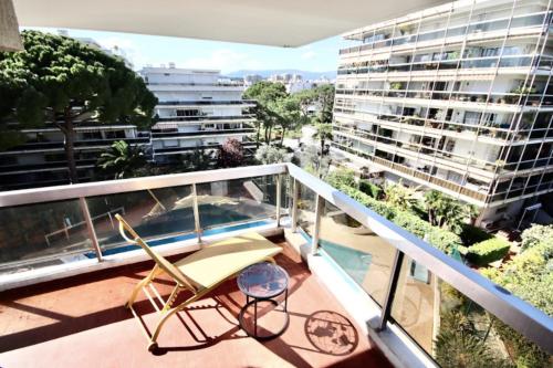 einen Balkon mit einem Stuhl und Blick auf ein Gebäude in der Unterkunft Bright cocoon with pool near the sea in Antibes