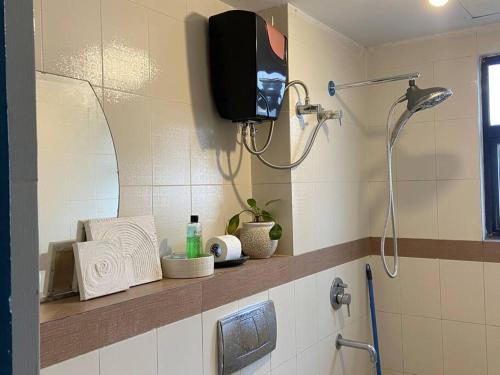 a bathroom with a shower and a tv on the wall at Peka' in Kolkata