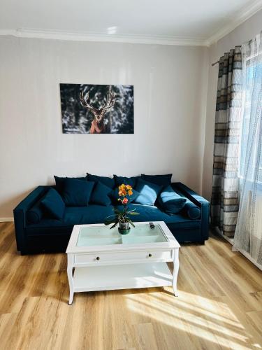 sala de estar con sofá azul y mesa de centro blanca en IBAY en Metzingen