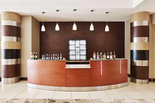 a bar in a hotel lobby with pendant lights at Embassy Suites by Hilton Alexandria Old Town in Alexandria