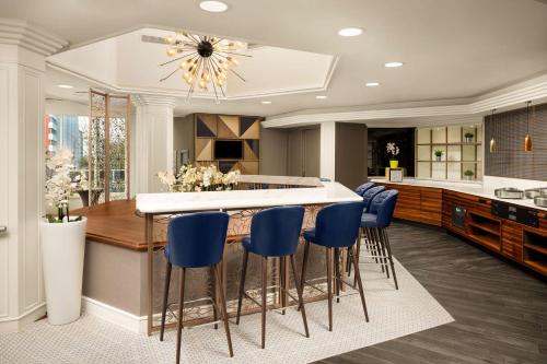 a kitchen with a large island with blue bar stools at DoubleTree by Hilton Luxembourg in Luxembourg