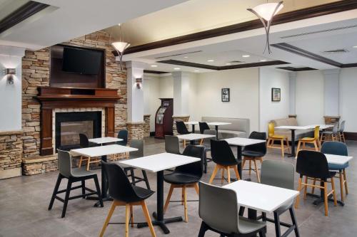 un restaurante con mesas y sillas y una chimenea en Hyatt House Sterling/Dulles Airport North en Sterling