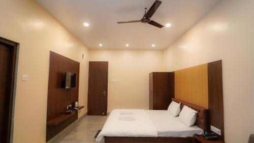 a bedroom with a bed and a ceiling fan at Hotel New Sagar Priya in Digha