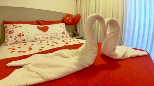 two swans towels are laying on a bed at Hotel Natur Campeche in Florianópolis