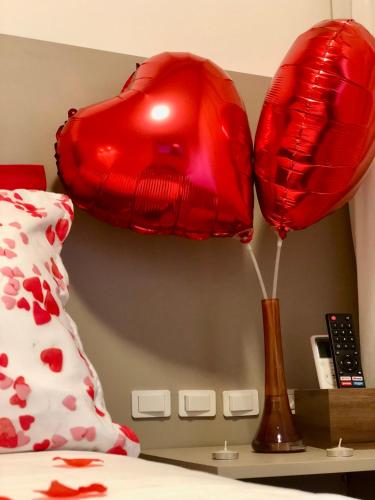 a red heart balloon and a lamp on a bed at Hotel Natur Campeche in Florianópolis