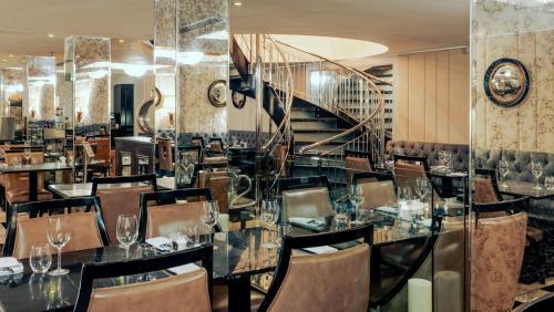 a dining room with a table and chairs and a staircase at Doubletree By Hilton London - Greenwich in London