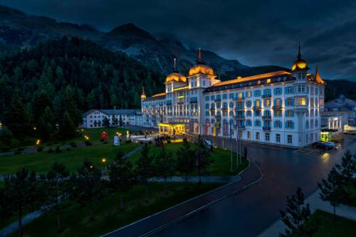 um grande edifício com luzes acesas à noite em Grand Hotel des Bains Kempinski em St. Moritz