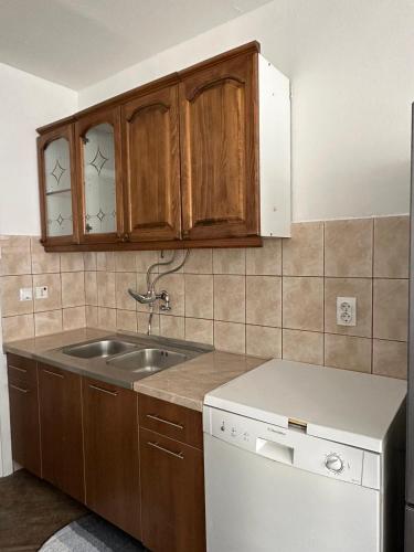 a kitchen with wooden cabinets and a sink at Rogatica Trg oslobodilaca in Rogatica