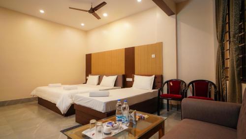 a hotel room with two beds and a couch at Hotel New Sagar Priya in Digha