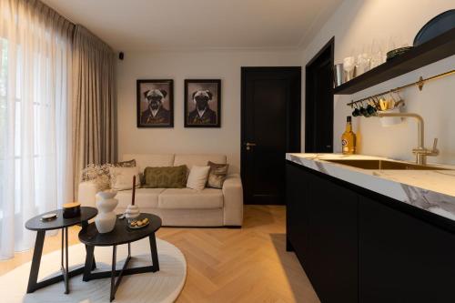 a kitchen and living room with a couch at Suite Heiloo in Heiloo