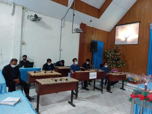 een groep mensen die aan een tafel in een kamer zitten bij Camping Rein apwisindo desa sarawet in Likupang