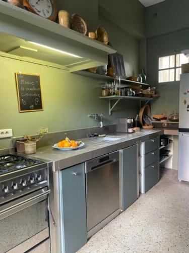 a kitchen with a stove and a plate of oranges on the counter at Belle maison, 3 chambres,avec un bassin, un jardin , dans le centre historique in Montpellier