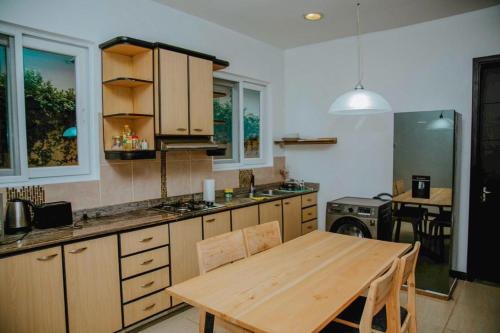 a kitchen with a wooden table and a dining room at Two Bedroom House With free WiFi in Masaki in Dar es Salaam
