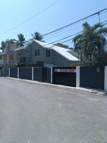 una calle con una valla y una casa en Bchome hostal, en Boca Chica