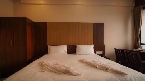 a bed with white sheets on top of it at Hotel New Sagar Priya in Digha