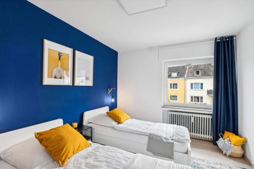 - une chambre avec 2 lits et un mur bleu dans l'établissement Moderne, Zentrale und Gemütliche Unterkunft, à Coblence