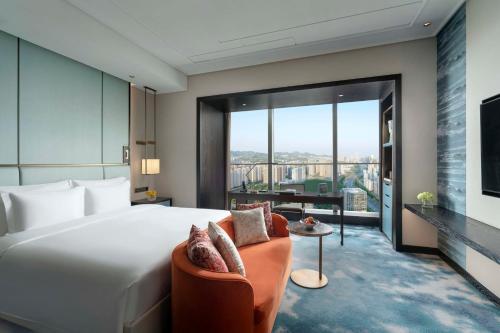 a bedroom with a large bed and a living room at Kempinski Hotel Jinan in Jinan