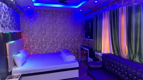 Habitación púrpura con cama y sofá en Relax Zone en Patna