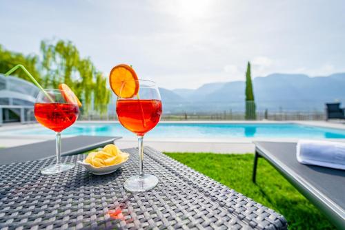 drie wijnglazen zittend op een tafel bij een zwembad bij Quellenhof in Termeno