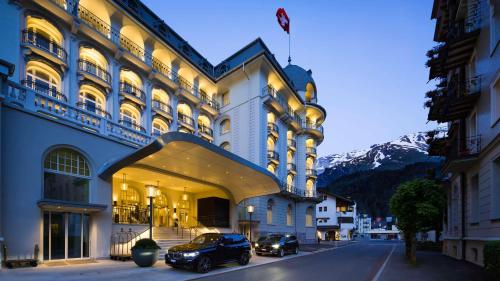 two cars parked in front of a building at Kempinski Palace Engelberg in Engelberg